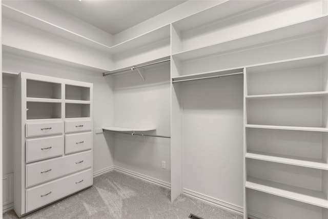 walk in closet featuring light carpet