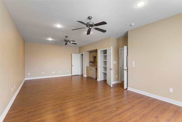 unfurnished living room with light wood-type flooring, recessed lighting, a ceiling fan, and baseboards