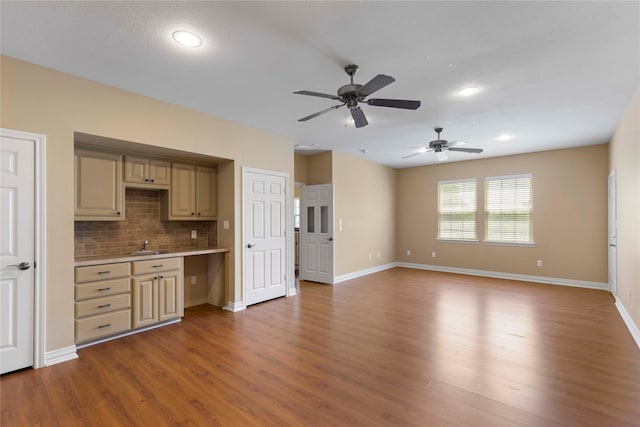 interior space featuring tasteful backsplash, wood finished floors, light countertops, ceiling fan, and baseboards