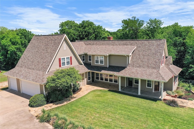 view of front of house featuring driveway, a chimney, a shingled roof, a porch, and a front lawn