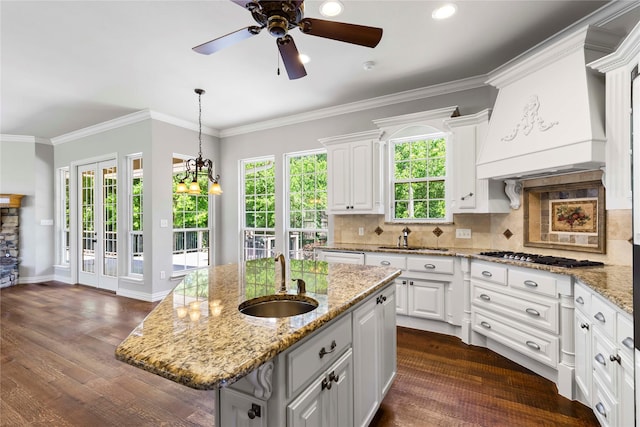 kitchen with a sink, white cabinets, stainless steel gas stovetop, and ceiling fan