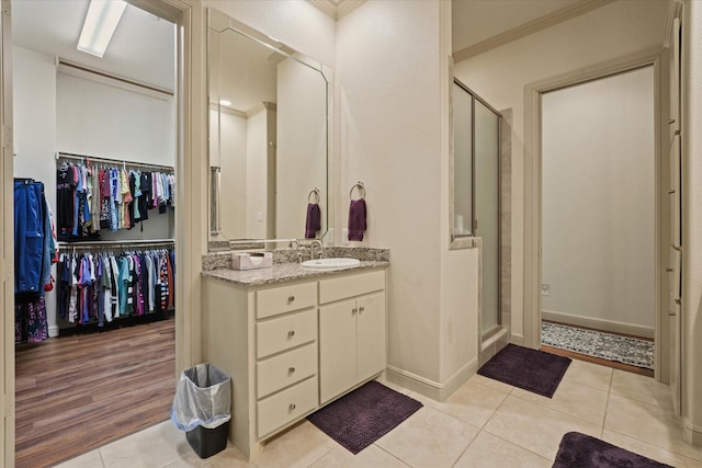 8405 Moore St, Frisco, TX 75034 - bathroom featuring vanity, ornamental molding, a walk in closet, and a stall shower