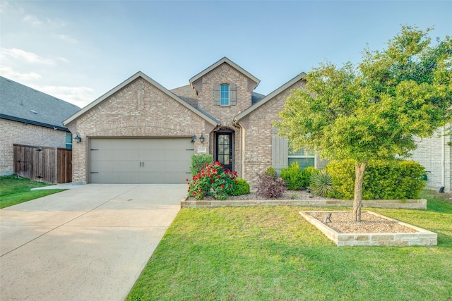 traditional-style home with driveway, a front yard, brick siding, and a garage