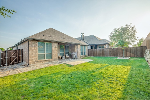 rear view of property with a patio area, brick siding, and a fenced backyard