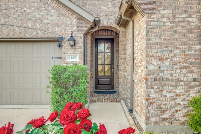 property entrance featuring brick siding and an attached garage