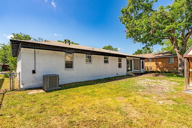 5409 Mallory Dr, Haltom City, TX 76117 - back of house with fence, a yard, central AC unit, and brick siding