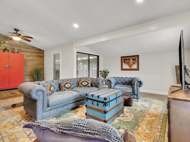 living room with light wood-style floors, wood walls, ceiling fan, baseboards, and lofted ceiling