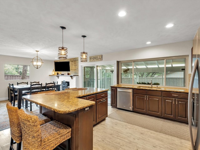 kitchen featuring a kitchen breakfast bar, stainless steel dishwasher, recessed lighting, and a sink