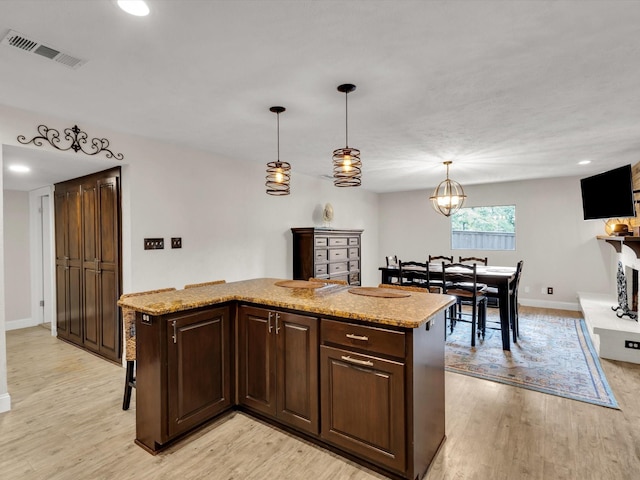 kitchen featuring light wood finished floors, visible vents, and baseboards