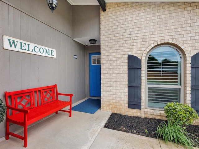 doorway to property featuring brick siding
