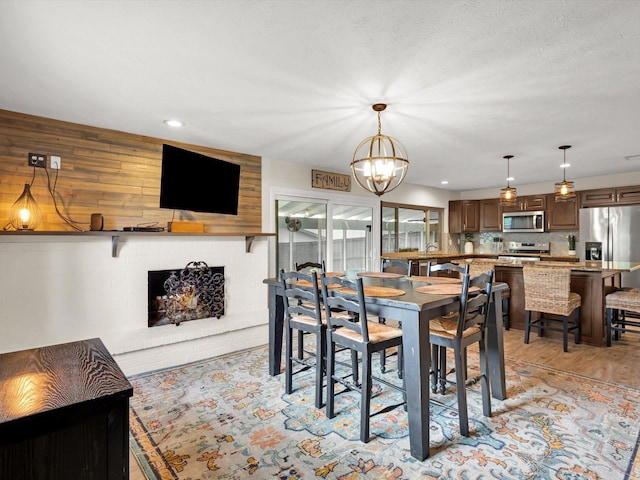 dining room with recessed lighting, a notable chandelier, and light wood finished floors