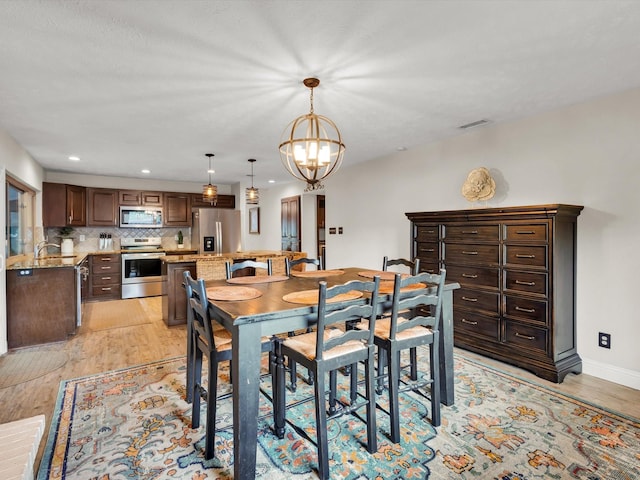 dining area featuring recessed lighting, a chandelier, light wood-style floors, baseboards, and visible vents