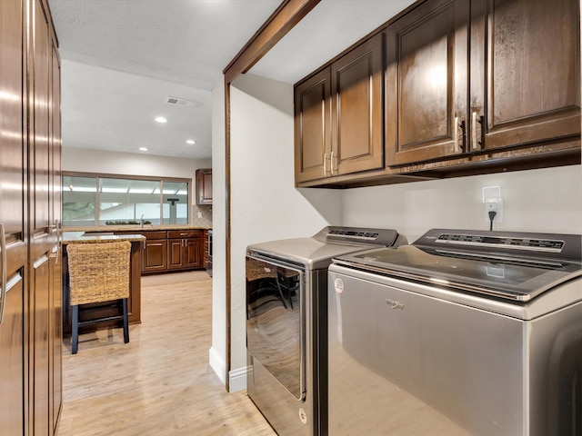 clothes washing area featuring recessed lighting, washer and dryer, light wood-style floors, cabinet space, and visible vents