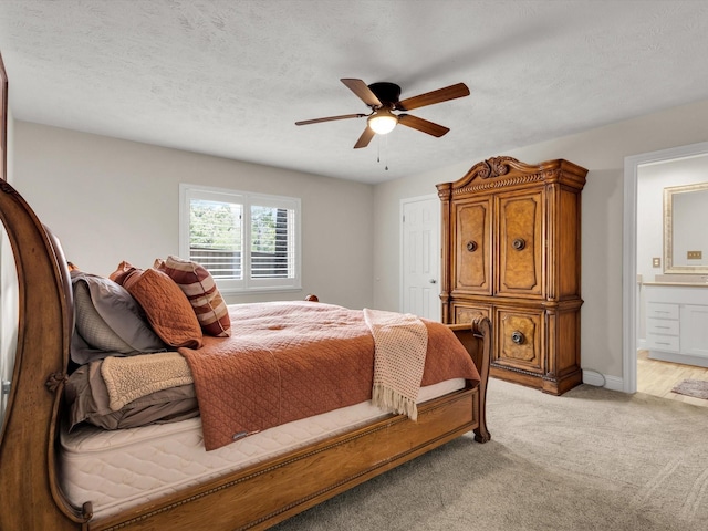 bedroom with light colored carpet, connected bathroom, a ceiling fan, and baseboards