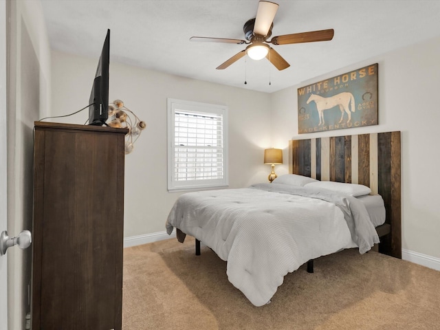 carpeted bedroom featuring baseboards and ceiling fan