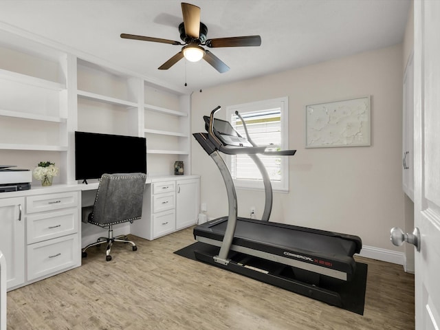 exercise room featuring baseboards, ceiling fan, and light wood-style flooring