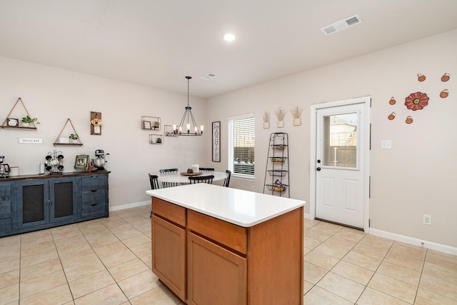 kitchen featuring a chandelier, decorative light fixtures, a kitchen island, visible vents, and light tile patterned flooring
