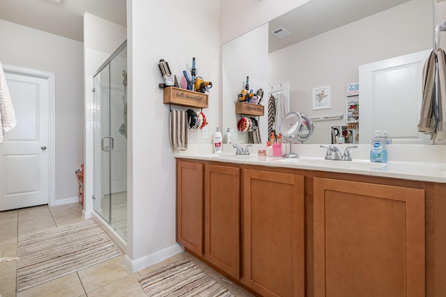 full bath featuring a sink, a shower stall, tile patterned floors, double vanity, and visible vents