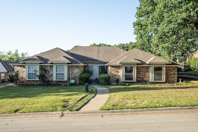 ranch-style house featuring brick siding and a front yard
