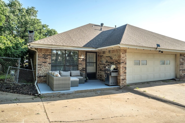 back of property featuring a garage, an outdoor living space, roof with shingles, concrete driveway, and fence