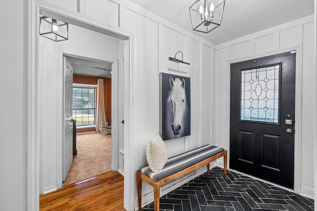 mudroom with baseboards and a notable chandelier