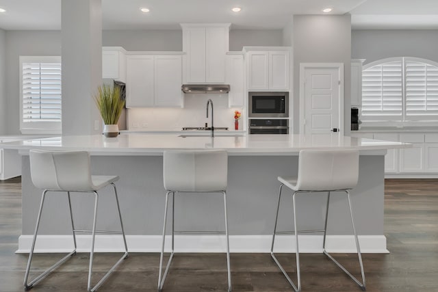 14316 Capridge Rd, Fort Worth, TX 76008 - kitchen with oven, built in microwave, under cabinet range hood, white cabinets, and recessed lighting