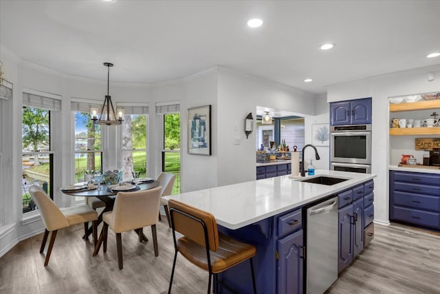 kitchen with a sink, blue cabinets, stainless steel appliances, and light countertops