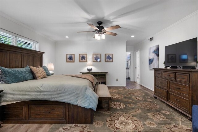 bedroom with wood finished floors, ornamental molding, and baseboards
