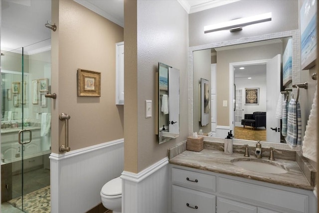 bathroom with wainscoting, ornamental molding, a shower stall, and toilet