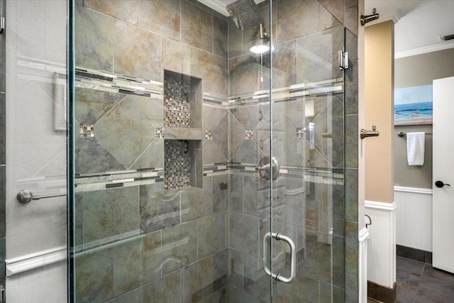 bathroom featuring visible vents, crown molding, a stall shower, and wainscoting