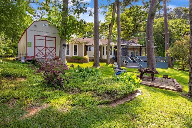 rear view of house featuring an outdoor structure, a lawn, a wooden deck, and a shed