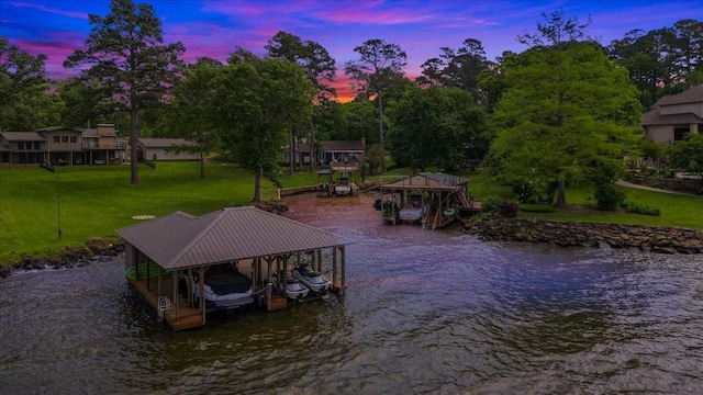 view of dock with a yard, a water view, and boat lift