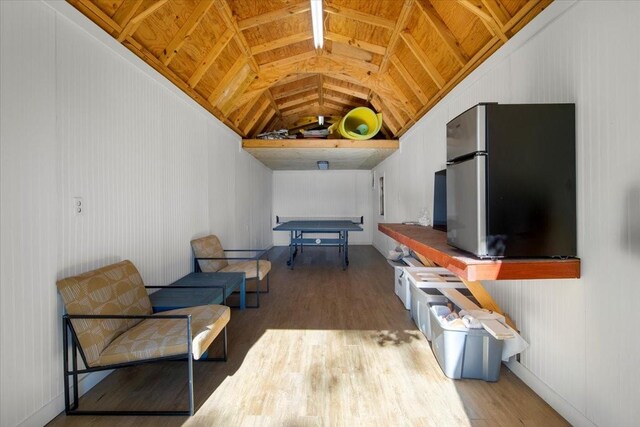 sitting room with wood finished floors and vaulted ceiling