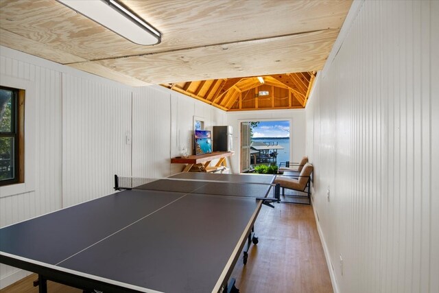 rec room featuring wooden ceiling, lofted ceiling with beams, wood walls, baseboards, and wood finished floors