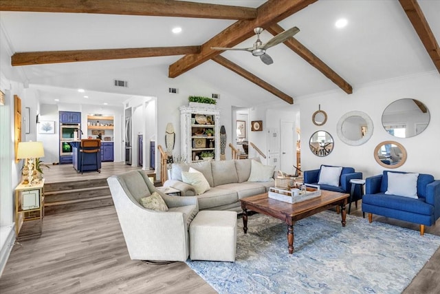 living area with visible vents, vaulted ceiling with beams, a ceiling fan, and light wood-style floors