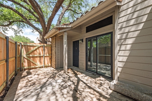 wooden deck featuring fence, a gate, and a patio