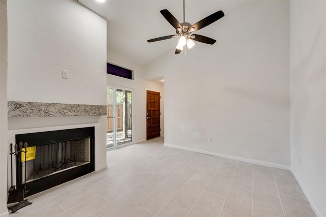 unfurnished living room featuring a fireplace, ceiling fan, high vaulted ceiling, and baseboards