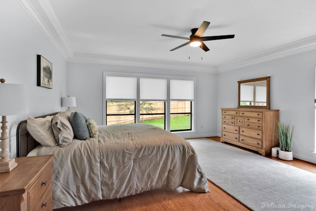 bedroom featuring crown molding, wood finished floors, baseboards, and ceiling fan