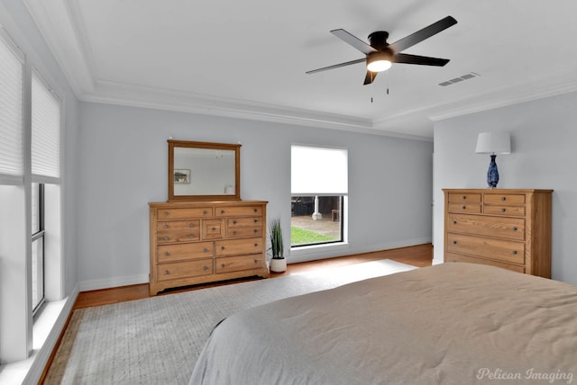 bedroom featuring ornamental molding, wood finished floors, baseboards, and a ceiling fan