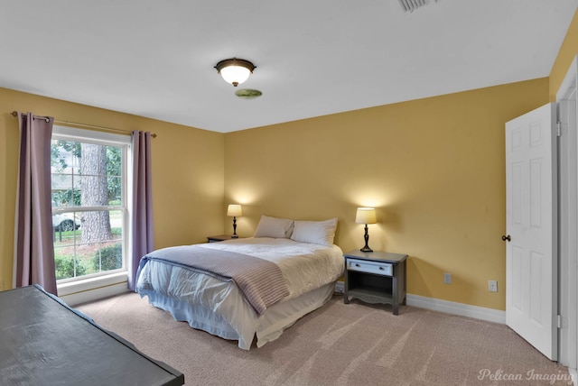 bedroom featuring light carpet and baseboards