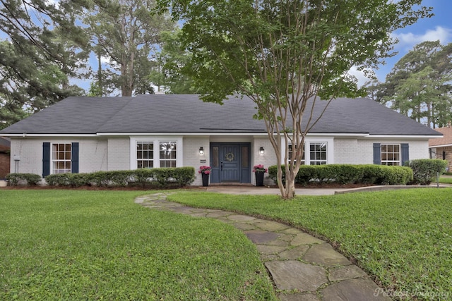view of front of house with brick siding and a front lawn