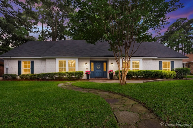 ranch-style home with brick siding and a front yard