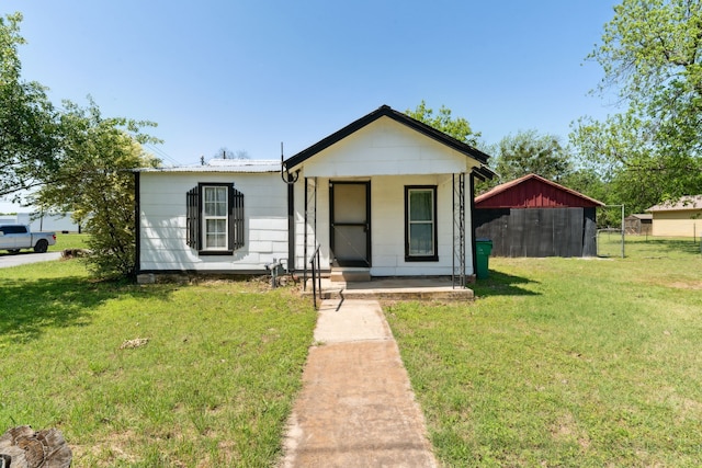 bungalow-style house featuring covered porch and a front yard