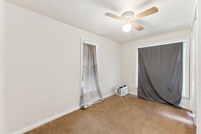 unfurnished room featuring a ceiling fan, baseboards, and carpet floors