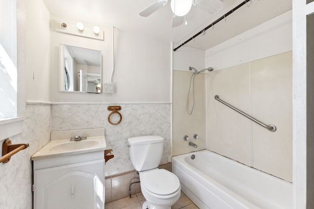 bathroom featuring vanity, shower / bath combination, toilet, a ceiling fan, and wainscoting