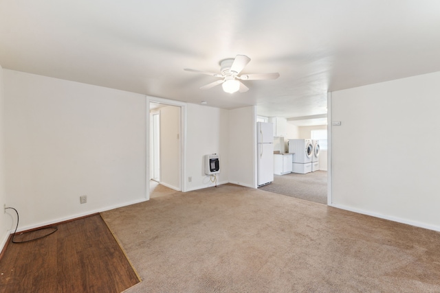 unfurnished living room featuring light colored carpet, independent washer and dryer, ceiling fan, and heating unit