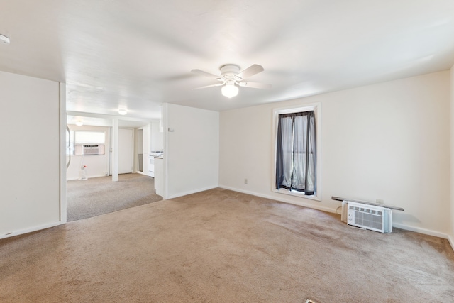 carpeted spare room with a ceiling fan, cooling unit, and baseboards