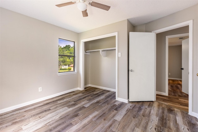 2820 Bois D Arc St, Commerce, TX 75428 - unfurnished bedroom with wood finished floors, a closet, baseboards, and ceiling fan
