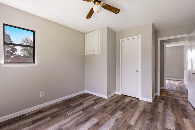 2820 Bois D Arc St, Commerce, TX 75428 - unfurnished bedroom with wood finished floors, baseboards, and a ceiling fan