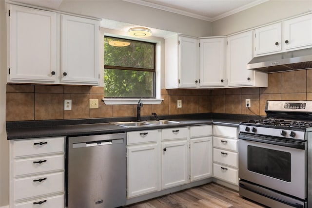 2820 Bois D Arc St, Commerce, TX 75428 - kitchen with appliances with stainless steel finishes, under cabinet range hood, a sink, dark countertops, and crown molding